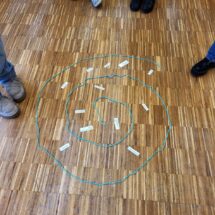 Foto von Schülerinnen, die zum Thema Gesundheitsprävention eine Schnecke aus einer Kordel gelegt haben.