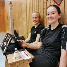 Zwei Badminton-Spielerinnen betätigen die Anzeigetafel.