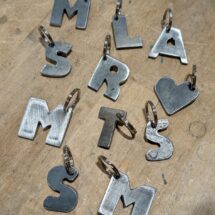 Selbst produzierte Schlüsselanhänger aus Metallblech.