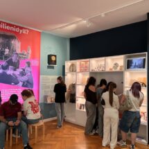 Innenansicht des Schulmuseums mit Schülerinnen, die Infotafeln studieren.