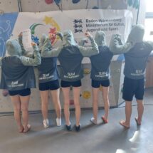 Schülerinnen und ein Schüler posieren mit einem Preisgeschenk!