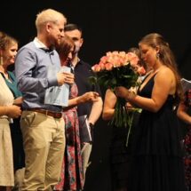 Eine Schülerin übergibt einer Lehrkraft eine Rose, um Danke zu sagen.