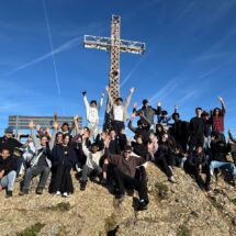 Gruppenfoto mit Schülerinnen und Schülern und Lehrkräften am Gipfelkreuz auf dem Hochgrat.