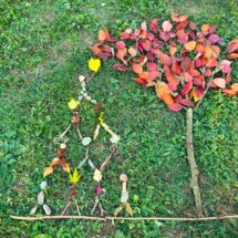 Landart aus bunten Blättern auf der grünen Wiese.