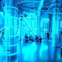Schülerinnen sitzen in einer Lichtinstallation im Atomium.